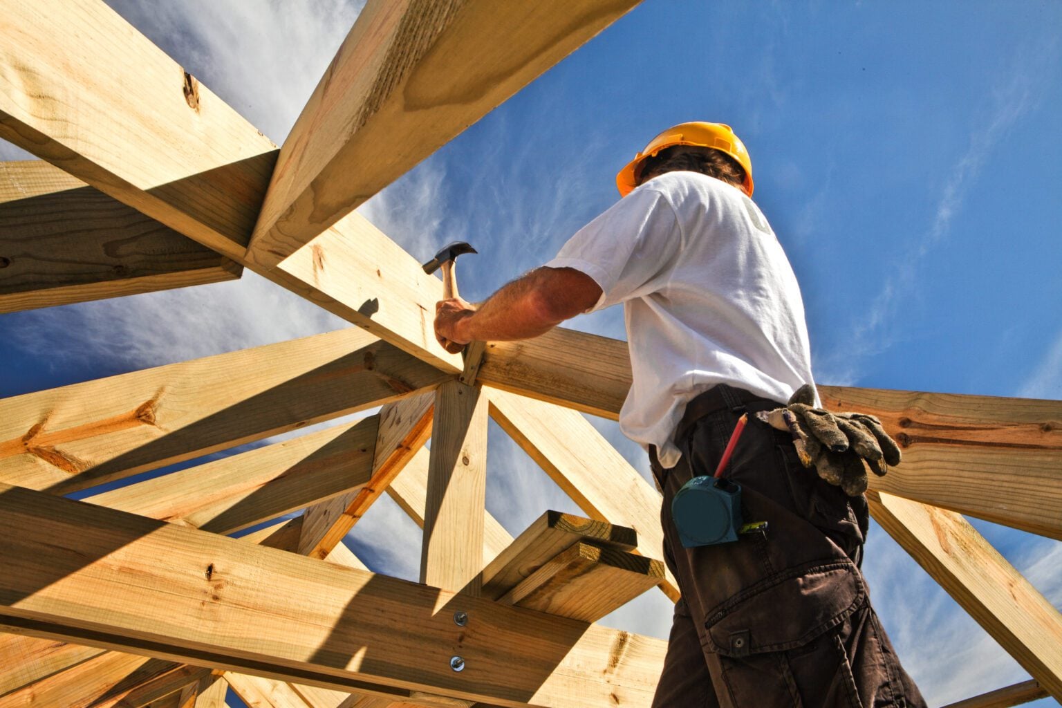 Construction worker hammering wooden beams