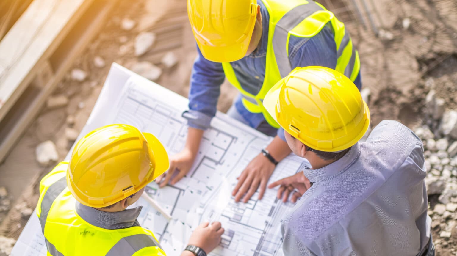 Construction workers reviewing blueprints together