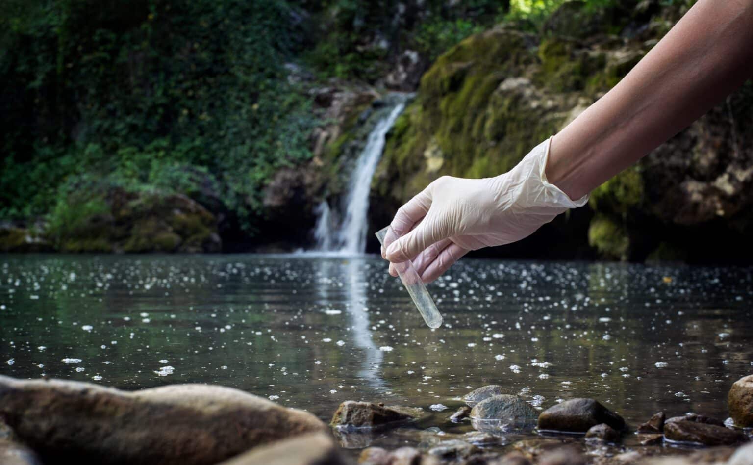 Collecting water sample near waterfall