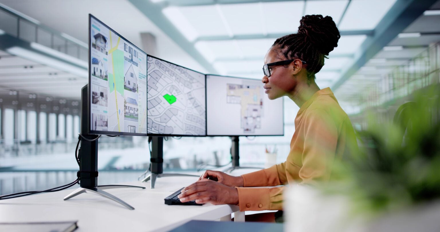 Woman working at multiple computer screens