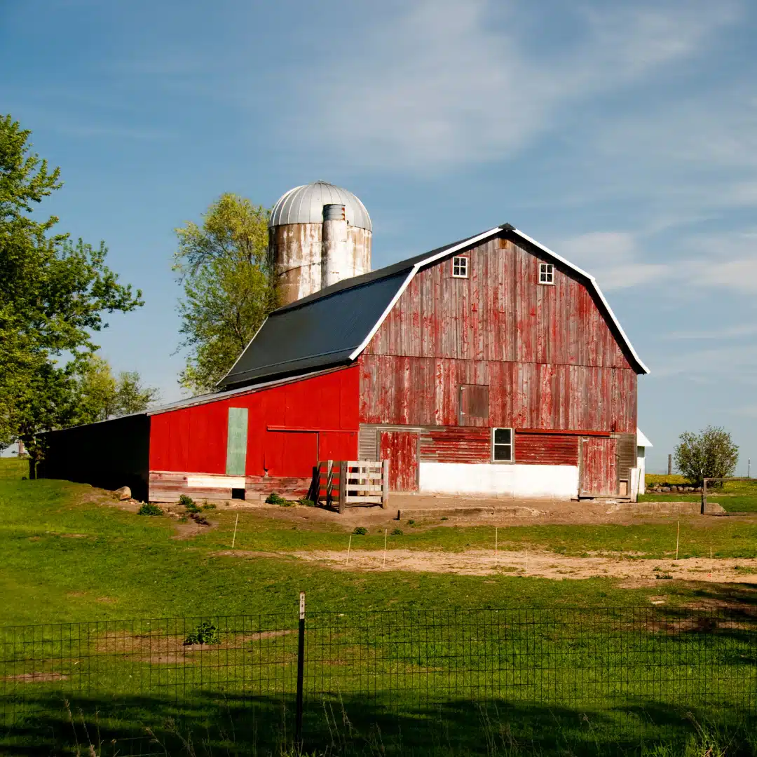Red barn with silo on farm
